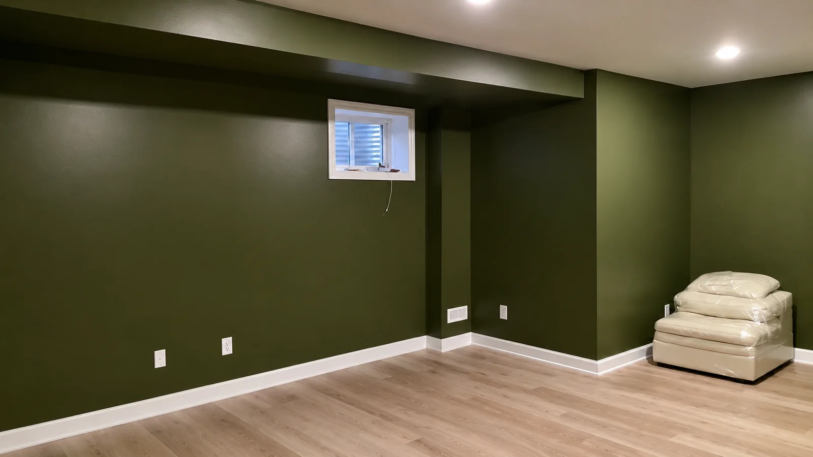 Freshly painted deep green basement with crisp white trim